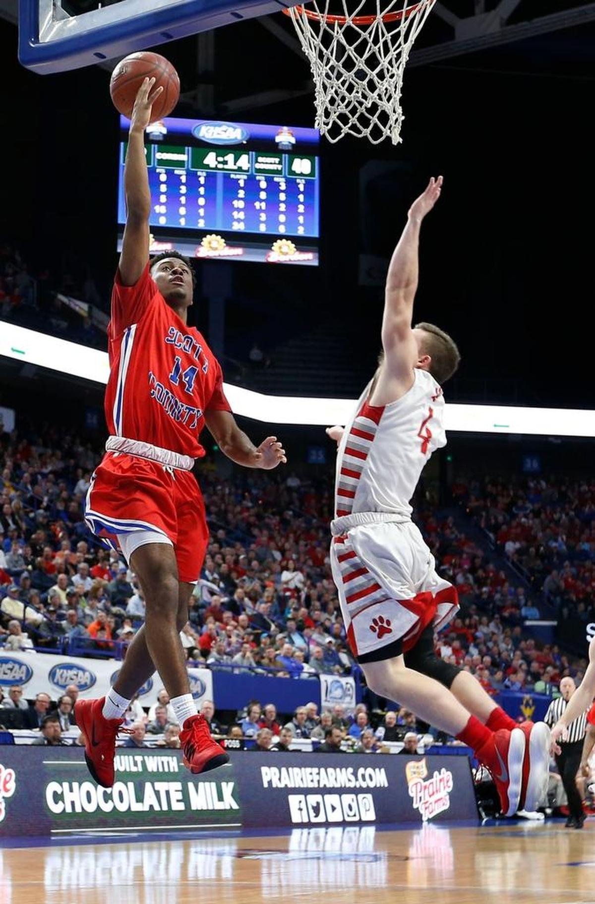 Scott County guard Glenn Covington (14) scored on Corbin guard Cameron Maguet (4) as Scott County played Corbin in the quarterfinal round of Whitaker Bank/KHSAA Boys' Sweet Sixteen in Rupp Arena. This is third quarter action. Scott County won 73-62.