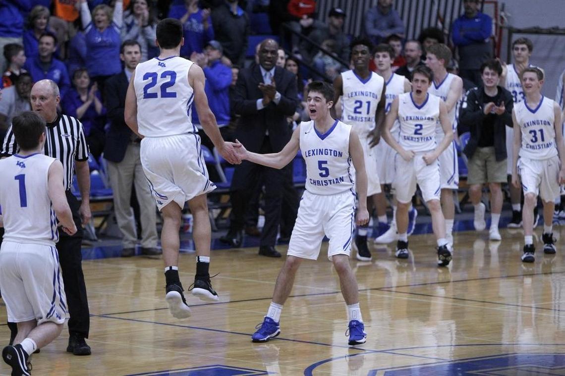 Lexington Christian's Ezekiel Grier slaps hands with Kyle Rode, after the Knights ended the first quarter up by 13 points against Lafayette during the boys' 43rd district championship at Lexington Christian.