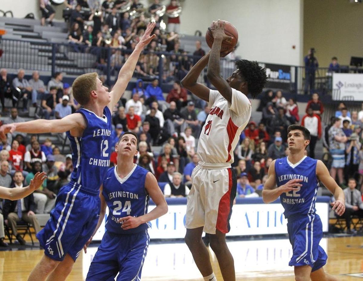 Paul Laurence Dunbar's Taveion Hollingsworth shoots against Lexington Christian Academy's Will Hacker during the semifinals of the 43rd district tournament in the Beuter Gymnasium in Lexington, Ky., Tuesday, February 21, 2017.