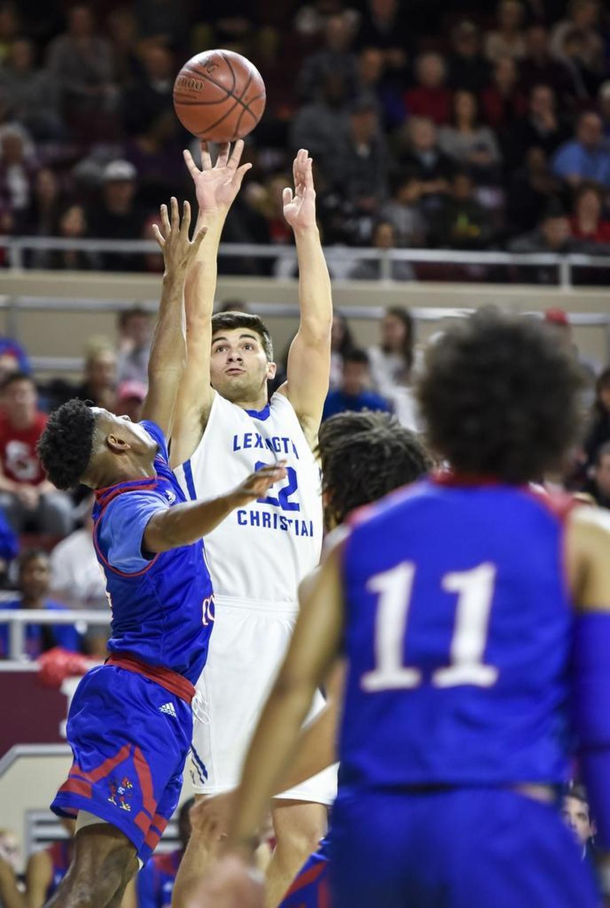 LCA's Kyle Rode (22) shoots over Scott County's Glenn Covington (14), during the finals of the boys 11th Region tournament, Monday, March 5, 2018, at EKU's McBrayer Arena in Richmond.