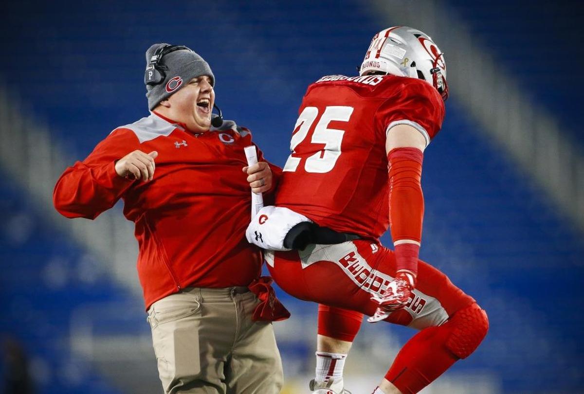Corbin's head coach Justin Haddix celebrates with Corbin's Ethan Wine (25) after his touchdown during the Class 3A Russell Athletic/KHSAA Commonwealth Gridiron Bowl championship game against Boyle County at Kroger Field in Lexington, Ky., Friday. Dec.1, 2017.