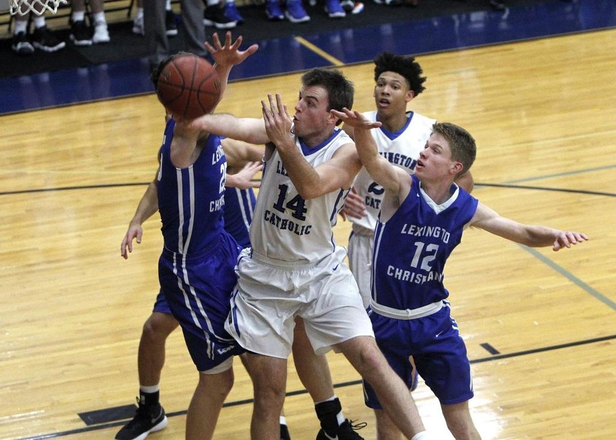 Lexington Catholic's Max Sparkman shoots against Lexington Christian's Will Hacker and Austin Hall, left, in the Bueter Gymnasium at Lexington Catholic in Lexington, Ky., Tuesday, January 2, 2018.