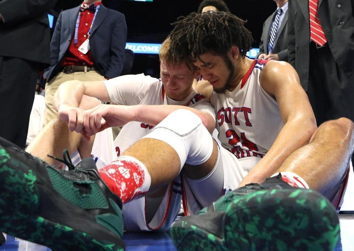 Scott County's Michael Moreno consoles senior Cooper Robb, left, Sunday after the Cardinals fell to Covington Catholic in the championship game of the 2018 Whitaker Bank KHSAA Sweet 16 basketball tournament at Rupp Arena.