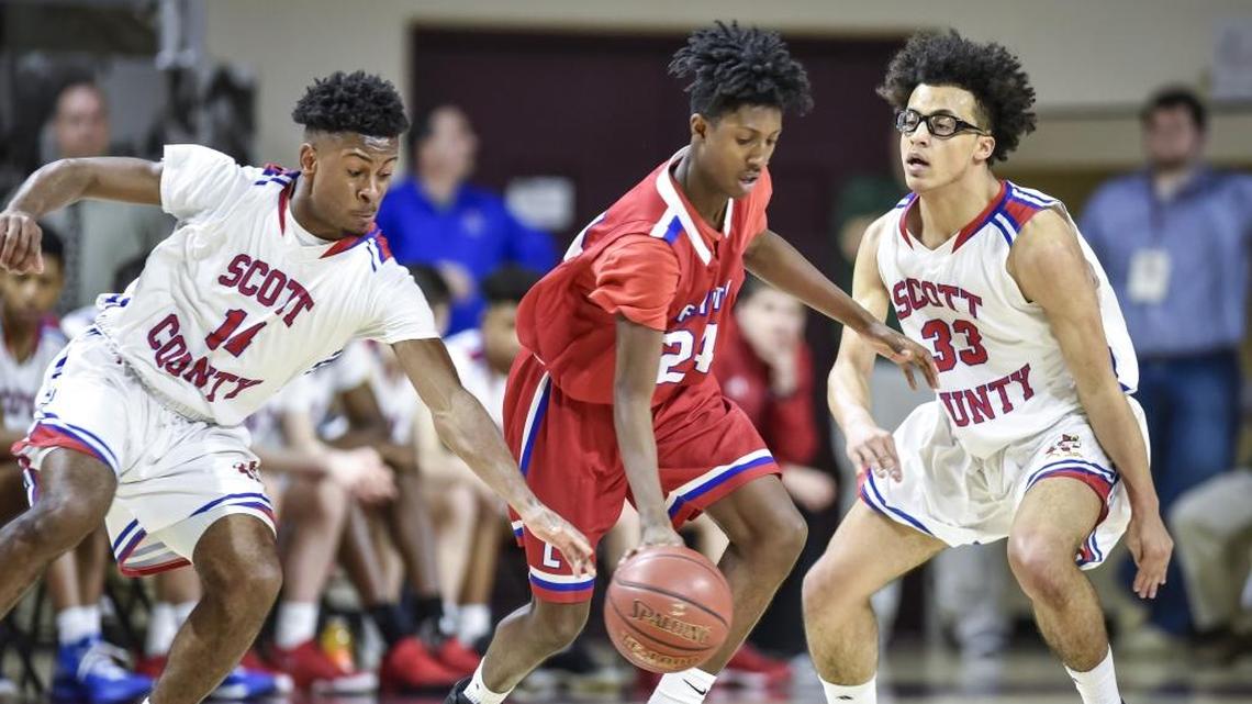 Scott County's Glenn Covington (14), left, and Lorenzo Williams (33), right, defend Lafayette's Alassane Diallo (24), during the semi finals of the boys 11th Region tournament, Saturday, March 3, 2018, at EKU's McBrayer Arena in Richmond.