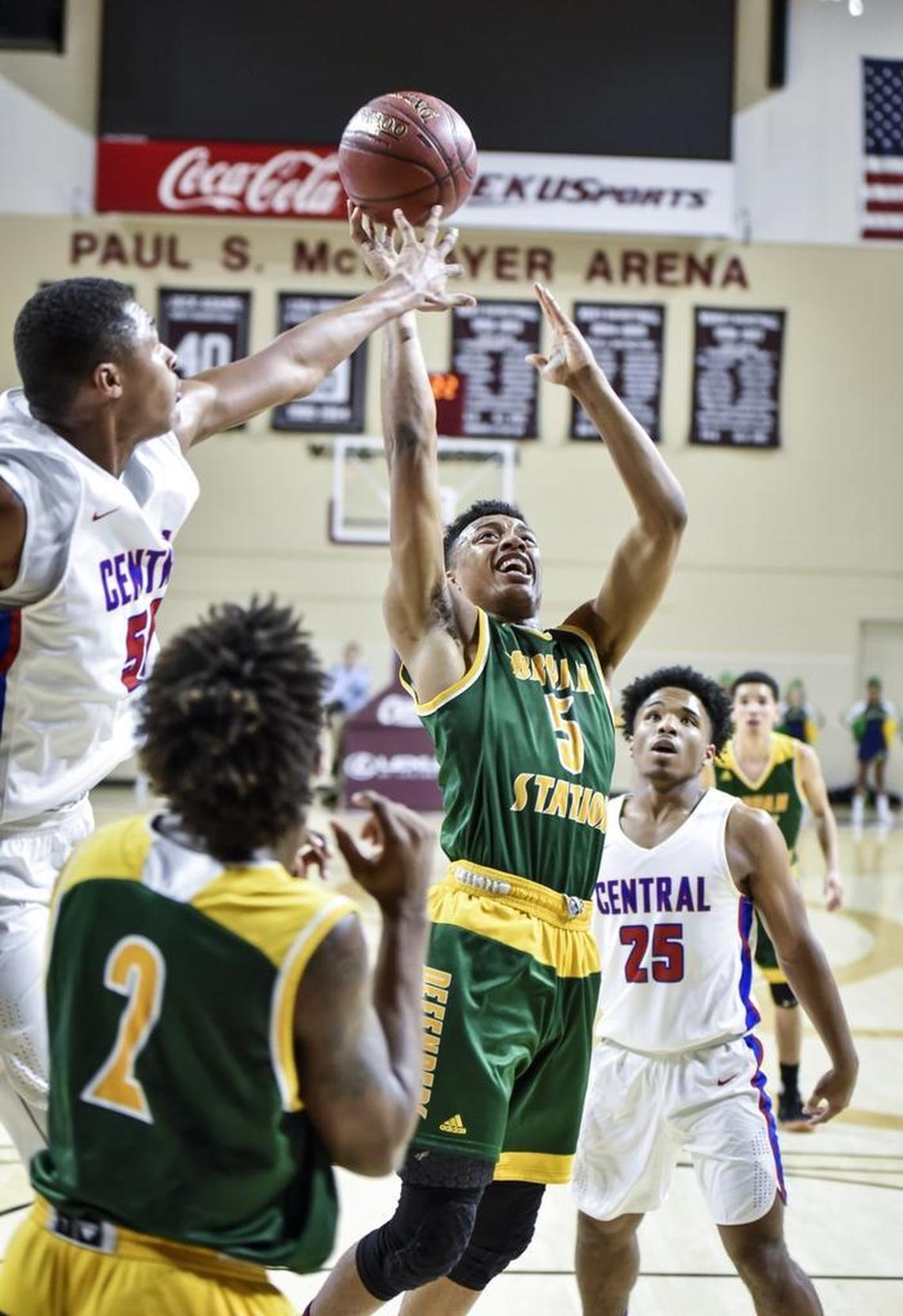 Bryan Station's Eric Boone (5) shoots over Madison Central's Isaiah Cozart (50), left, during the first round of the 11th Region tournament, Wednesday night, February 28, 2018, at EKU's McBrayer Arena in Richmond.