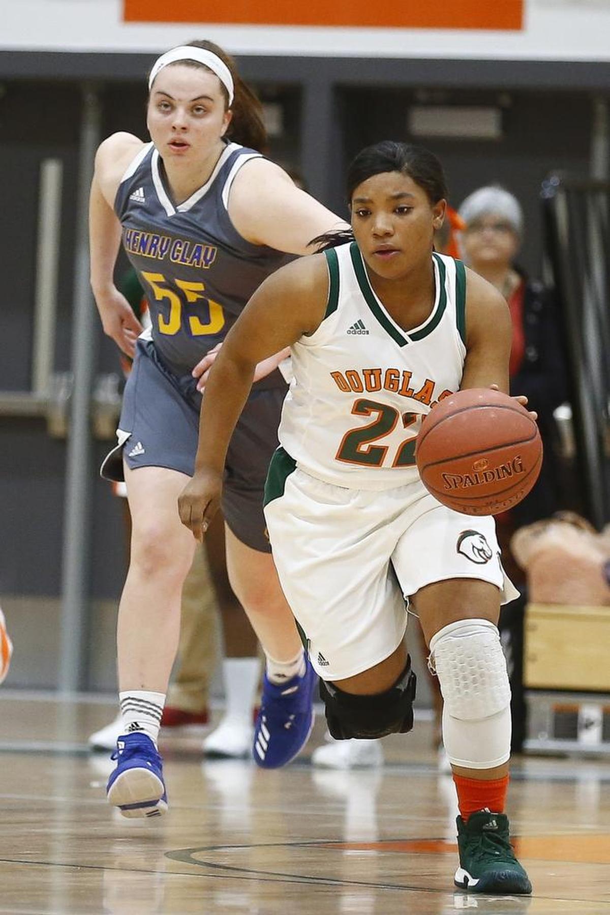 Frederick Douglass' Ashanti Hollingsworth (22) drives past Henry Clay's Grace Branchini (55) during their game at Frederick Douglass High School in Lexington, Ky., Tuesday, Nov. 28, 2017.