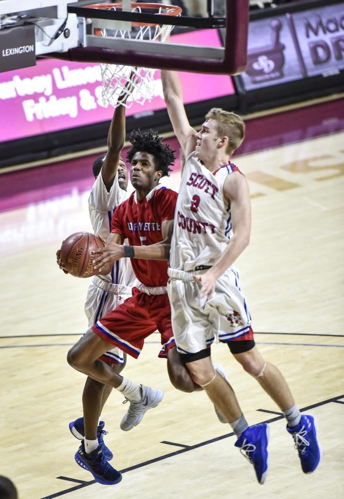 Lafayette's TeAndre Newcomb (5) drives between Scott County's Cam Fluker (1), left, and Bryce Long (2), during the semi finals of the boys 11th Region tournament, Saturday, March 3, 2018, at EKU's McBrayer Arena in Richmond.