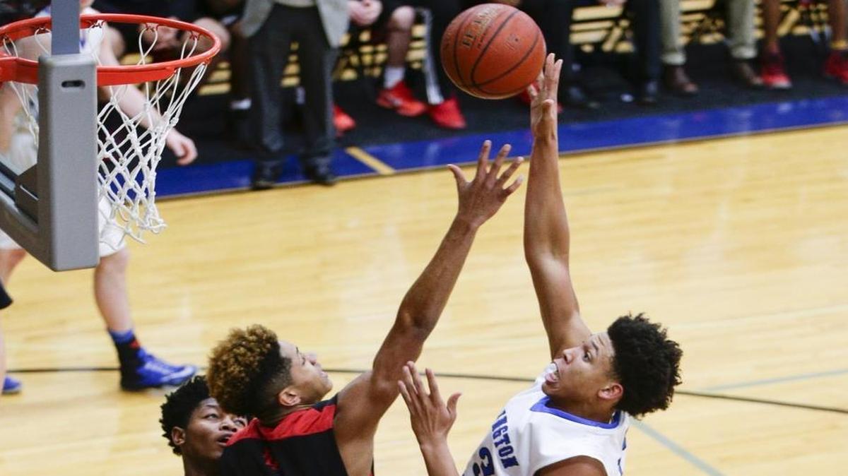 Lexington Catholic’s Zan Payne put in two of his 12 points over Dunbar's Isaiah Yeast (2) as Lexington Catholic defeated Dunbar 53-52 on Thursday January 19, 2017 in Lexington, Ky.
