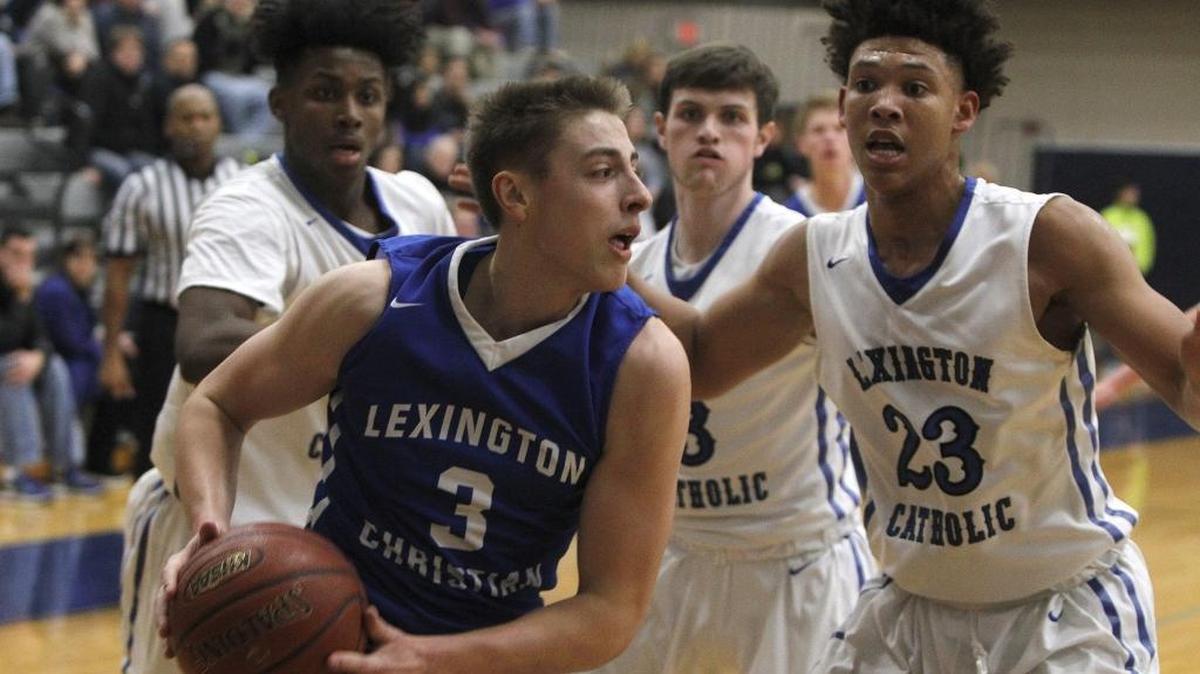 Lexington Christian Academy's Carter Hendricksen moves to the basket against Lexington Catholic's Zan Payne in the Bueter Gymnasium at Lexington Catholic in Lexington, Ky., Tuesday, January 2, 2018.