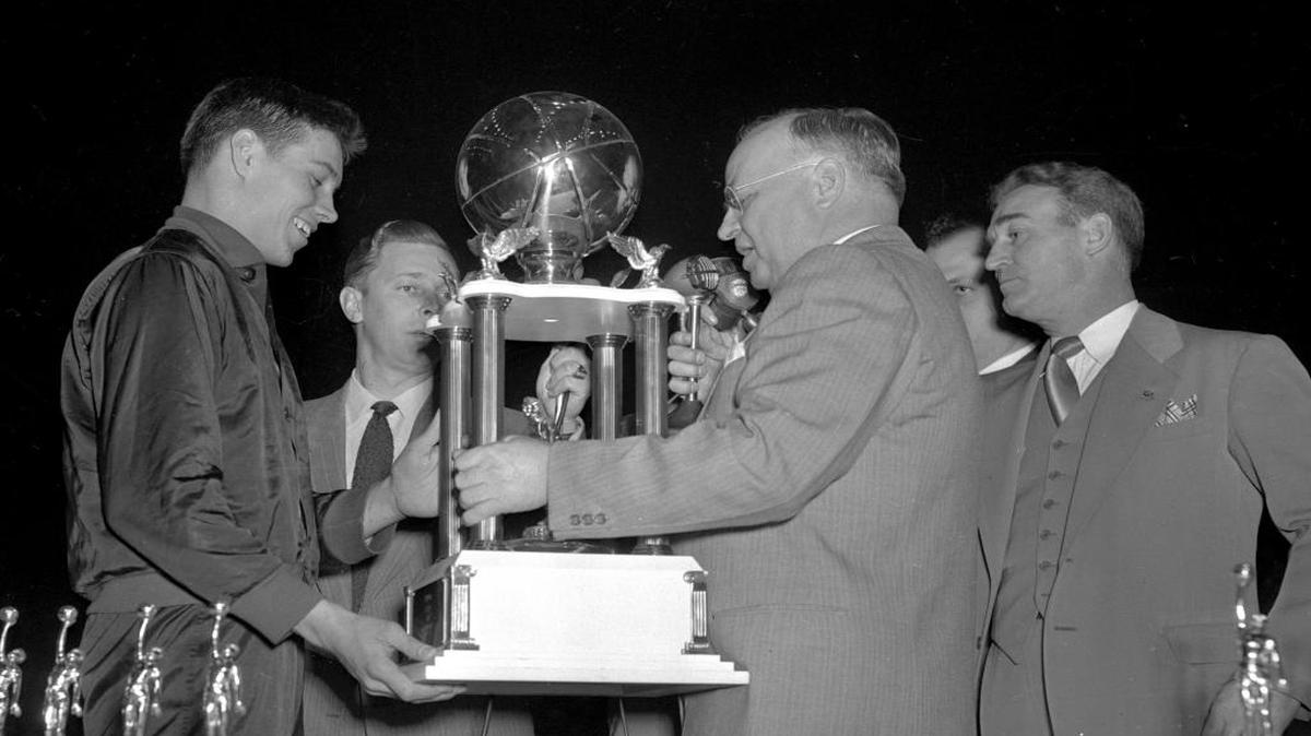 Owensboro star Cliff Hagan, left, received the state high school basketball championship trophy March 19, 1949 in Louisville. Hagan scored 41 points leading the Red Devils to a 65-47 victory over Lafayette.