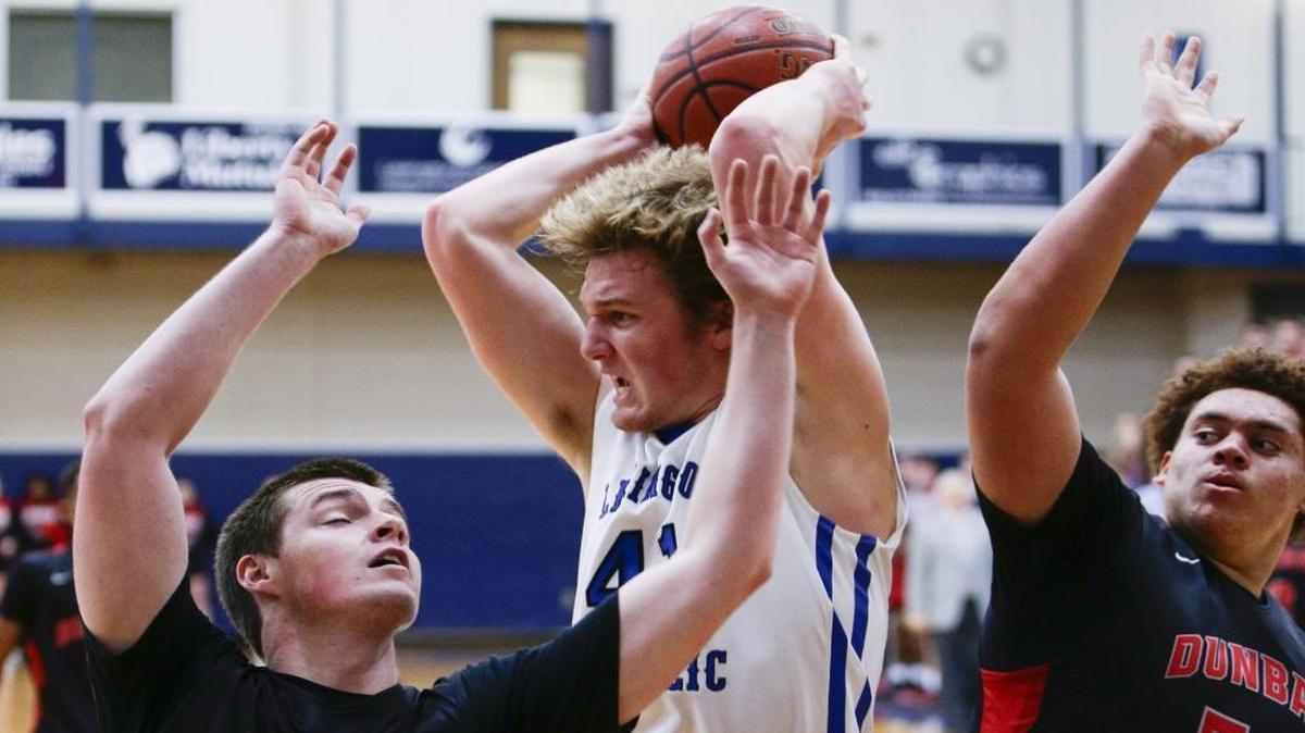 Lexington Catholic’s Peter Whitman, center, pulled down a rebound over Dunbar's Matthew Browne, left, and Kaelen Whiteside on Jan. 18.