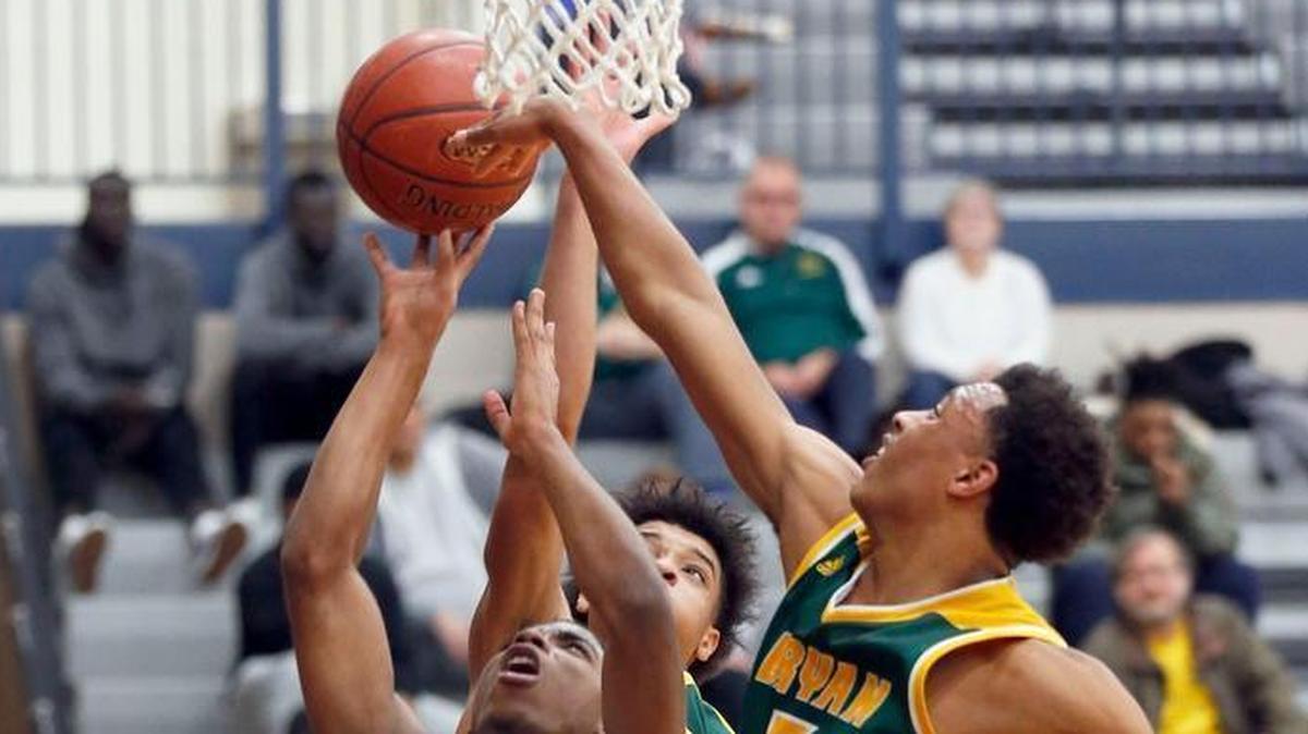 University Height's KyKy Tandy (15) shot in front of Bryan Station's Eric Boone (5) and Myles Morones (23) in the second quarter as Bryan Station High School played University University Heights in theTraditional Bank Holiday Classic played at Lexington Catholic High School in Lexington Ky., Wednesday, December 27, 2017. Bryan Station won 82-69.