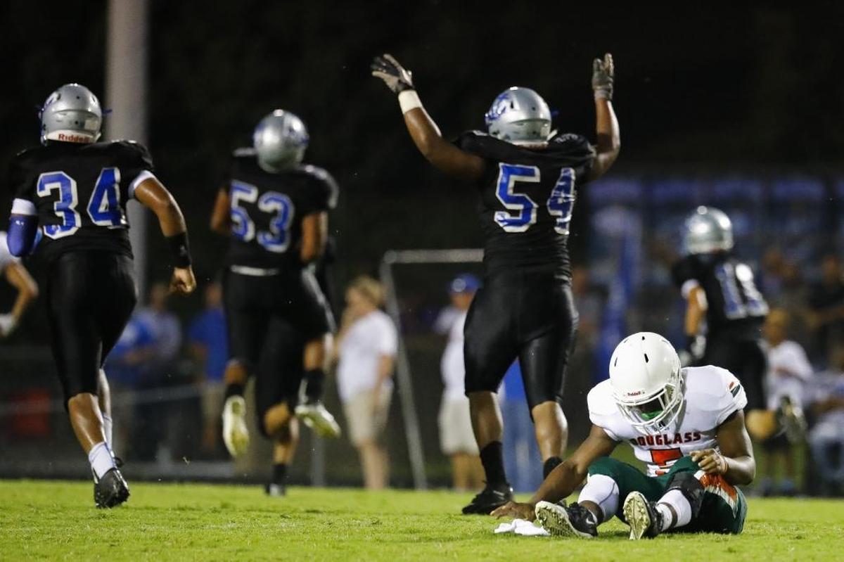 Frederick Douglass' Nate Gay (5) sits on the field as Danville's James Patton (54) celebrates an interception in the first quarter of their game at Danville High School in Danville, Ky., Saturday, Aug 19, 2017.