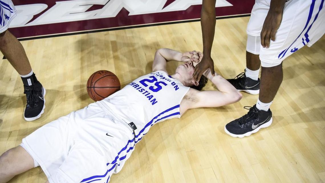 LCA's Austin Hall (25) is consoled by teammate LCA's Isaiah Hunt (21) after losing to Scott County 46-44, during the finals of the boys 11th Region tournament, Monday, March 5, 2018, at EKU's McBrayer Arena in Richmond. Hall was unable to get off what could have been the game tying shot.