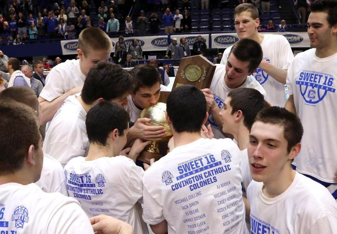 Covington Catholic players kiss the trophy after winning the championship game of the 2018 Whitaker Bank KHSAA Sweet 16 basketball tournament at Rupp Arena.