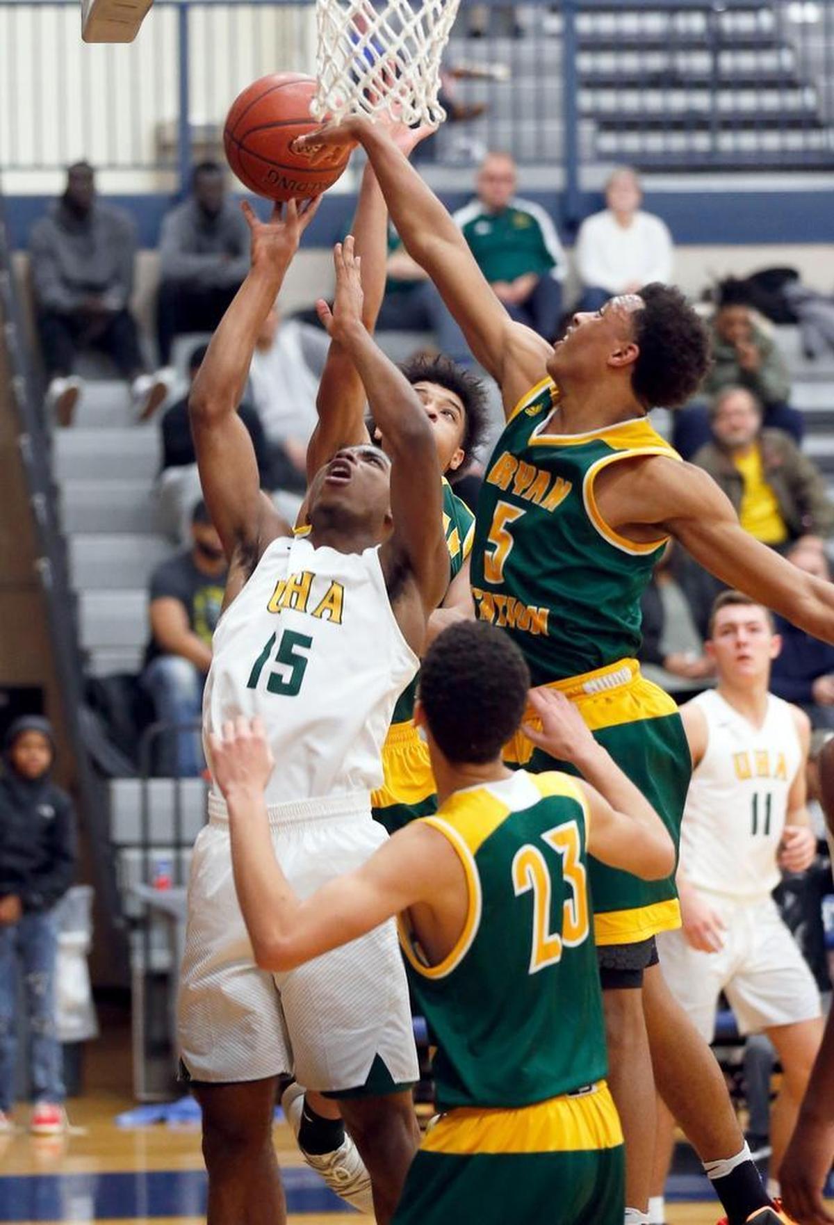 University Height's Dekeyvan Tandy (15) shot in front of Bryan Station's Eric Boone (5) and Myles Morones (23) in the second quarter as Bryan Station High School played University University Heights in the Traditional Bank Holiday Classic played at Lexington Catholic High School in Lexington Ky., Wednesday, December 27, 2017. Bryan Station won 82-69.