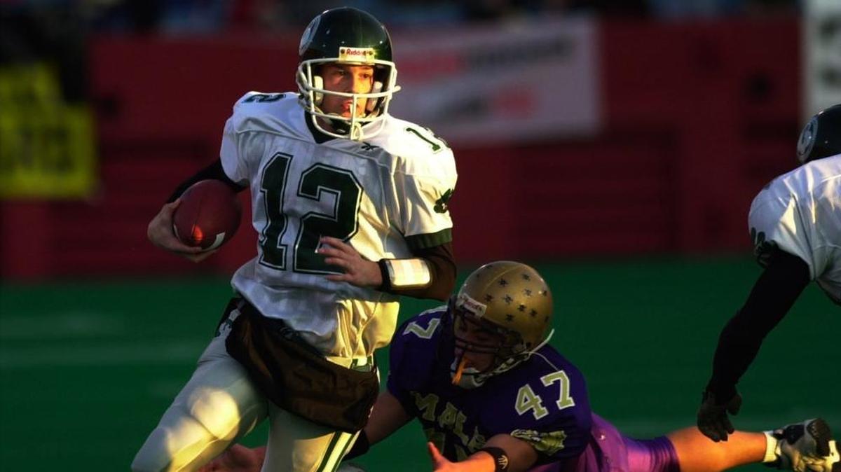 Trinity quarterback Brian Brohm, 12, eludes the tackle of Male defender Matt Barker during the first half in the Class 4A championship won by Trinity 45-18 on Saturday, Dec. 1, 2001 in Louisville, Kentucky.