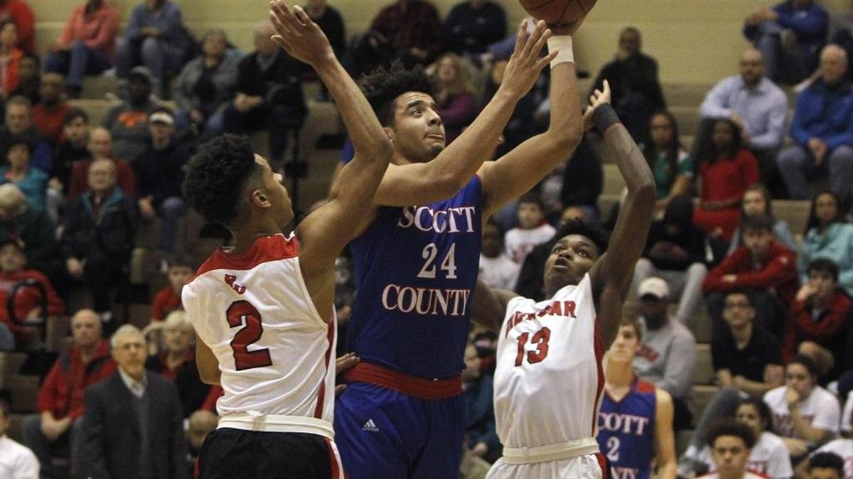 Scott County's Michael Moreno shoots against Paul Laurence Dunbar's Isaiah Yeast, left, and Star Ifeacho in the S. T. Roach Gymnasium in Lexington, Ky., Thursday, February 17, 2017.