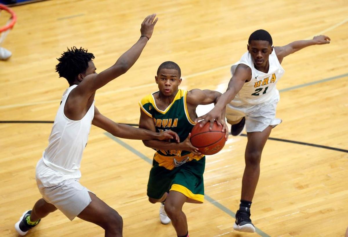 Bryan Station's Keaton Simpson (11) had the ball stripped by University Height's DJ Quarles (21) and Malik Lovan, left, in the 3rd quarteras Bryan Station High School played University University Heights in theTraditional Bank Holiday Classic played at Lexington Catholic High School in Lexington Ky., Wednesday, December 27, 2017. Bryan Station won 82-69. Bryan Station's 11- Keaton Simpson had the ball stripped by University Height's 21- DJ Quarles and 2- Malik Lovan, left, in the 3rd quarter
