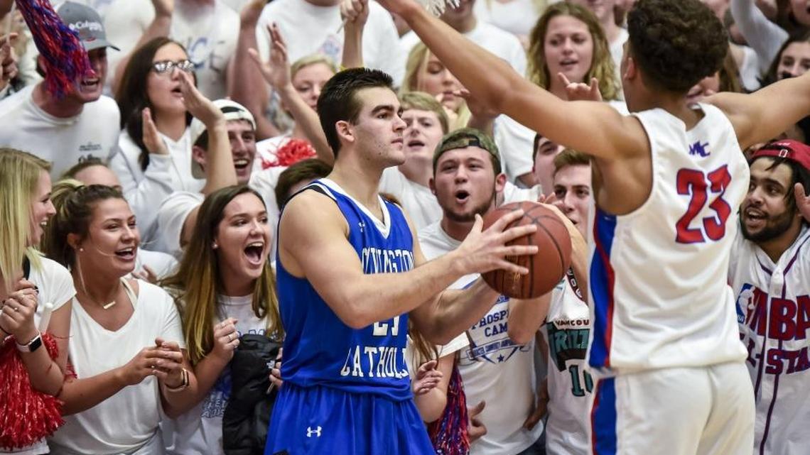 Covington Catholic's AJ Mayer (21) looks to inbound the ball against Madison Central's Dustin Geralds (23), and under the pressure of the Madison Central fans, February 16, 2018, at Madison Central High School in Richmond.