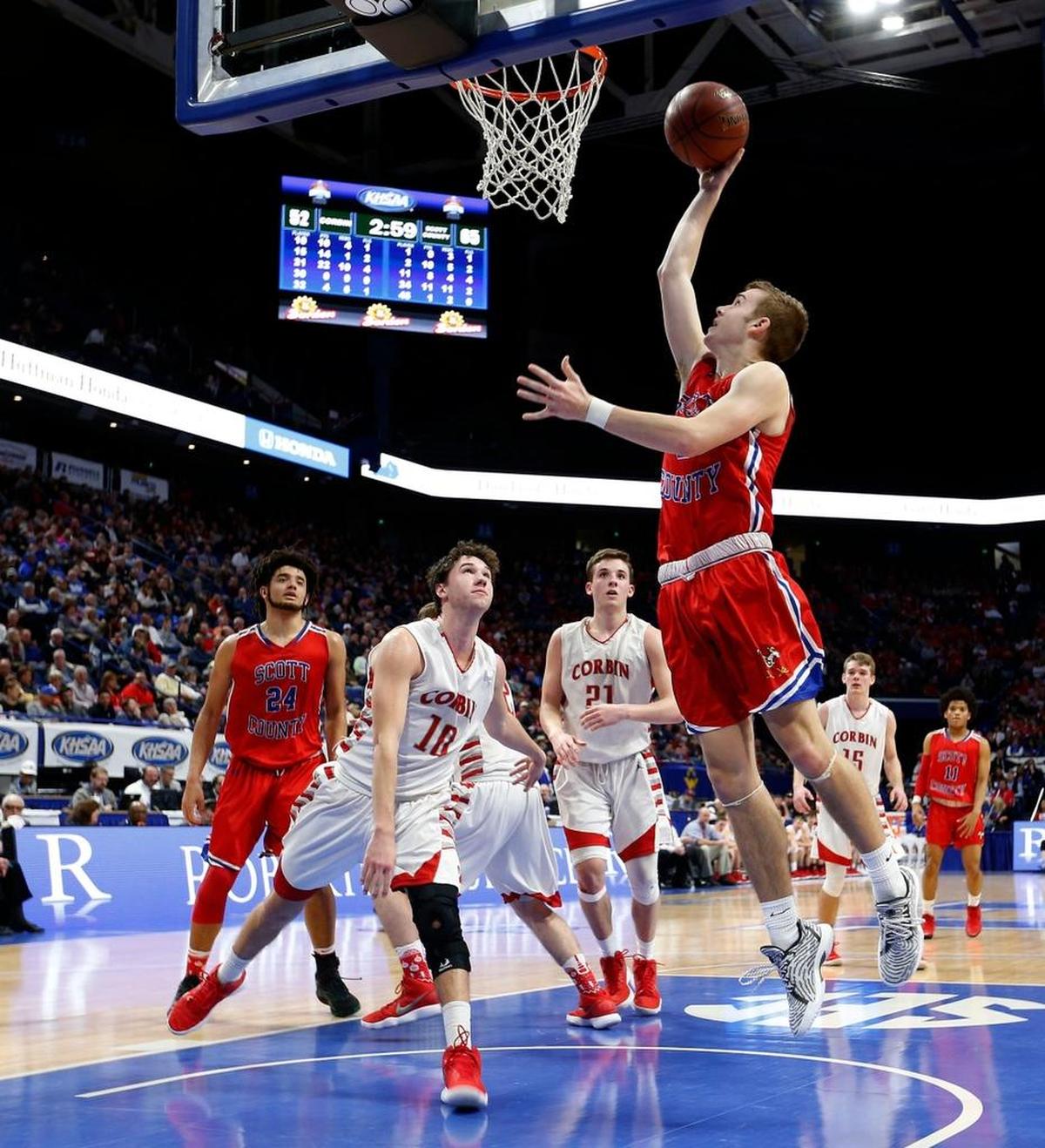 Scott County guard Bryce Long (2) scored on Corbin guard Chase Sanders (10) as Scott County played Corbin in the quarterfinal round of Whitaker Bank/KHSAA Boys' Sweet Sixteen in Rupp Arena. This is fourth quarter action. Scott County won 73-62.