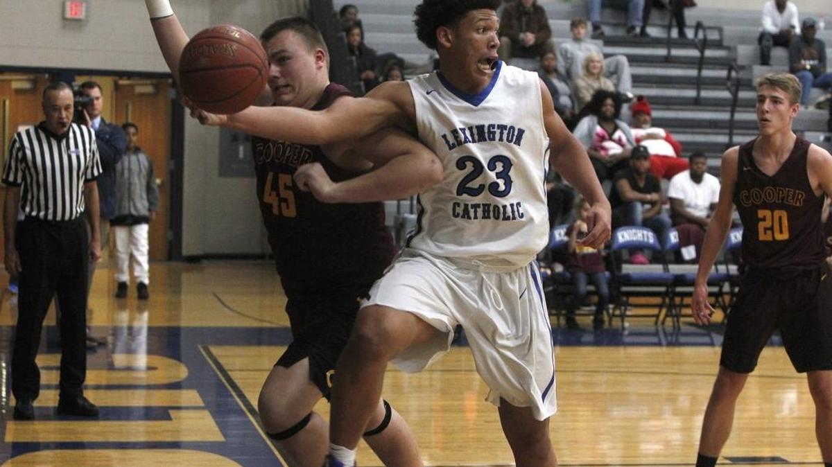Lexington Catholic's Zan Payne makes a save while being elbowed by Cooper's Daniel Wasser during the finals of the boys' Traditional Bank Holiday Classic in the Beuter Gymnasium at Lexington Catholic in Lexington, Ky., Friday, December 30, 2016.