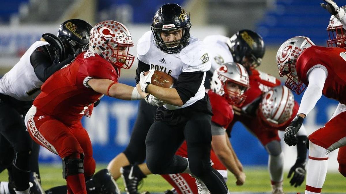 Boyle County’s Blake Biggs, center, ran the ball past Corbin’s Noah Taylor, left, during the Class 3A championship game at Kroger Field in Lexington on Dec. 1, 2017. Boyle County won 40-21.