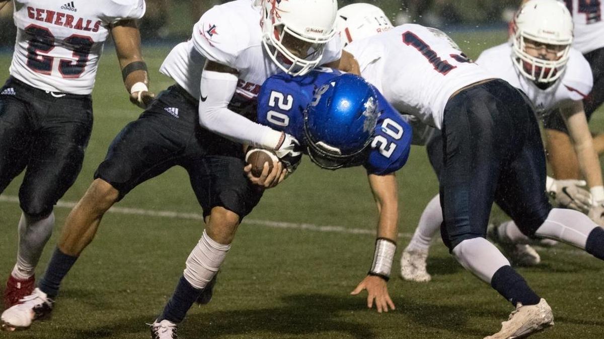 Lexington Catholic's Keith Brinkman (20) was brought down by Lafayette's Kuantaze Cooper as Lexington Catholic hosted Lafayette on Friday Sept. 1, 2017 in Lexington, Ky.