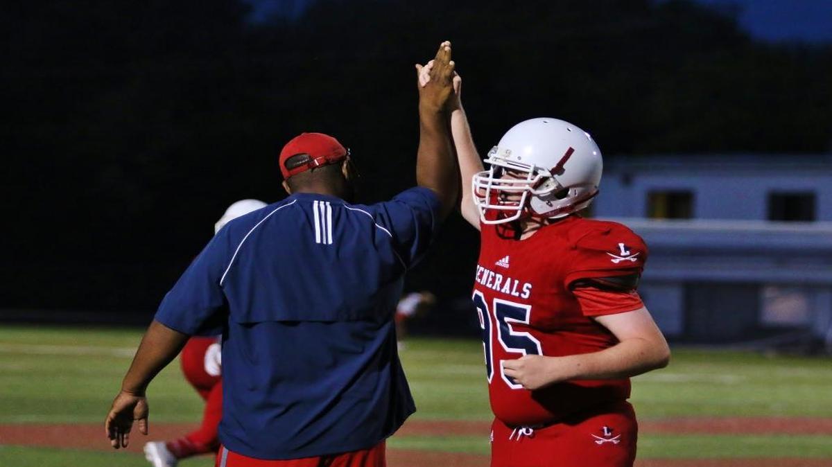 Lafayette High School defensive lineman Will Watkins, right, high-fived assistant coach Matt Brown after the Generals’ scrimmage versus Woodford County High School on Thursday, Aug. 10, 2017.
