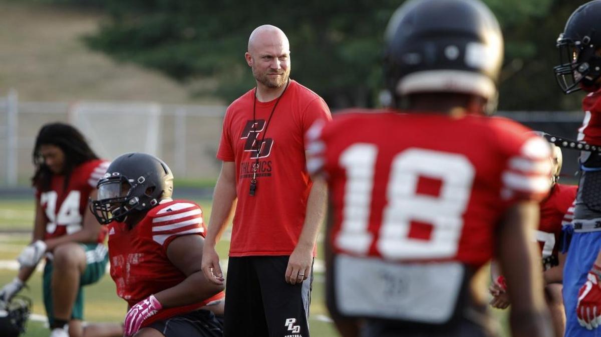 Paul Laurence Dunbar head football coach Chris Mullins checks out the action during the team's mini-camp at Jon Akers Stadium in Lexington, Ky., Thursday evening, August 3, 2017.