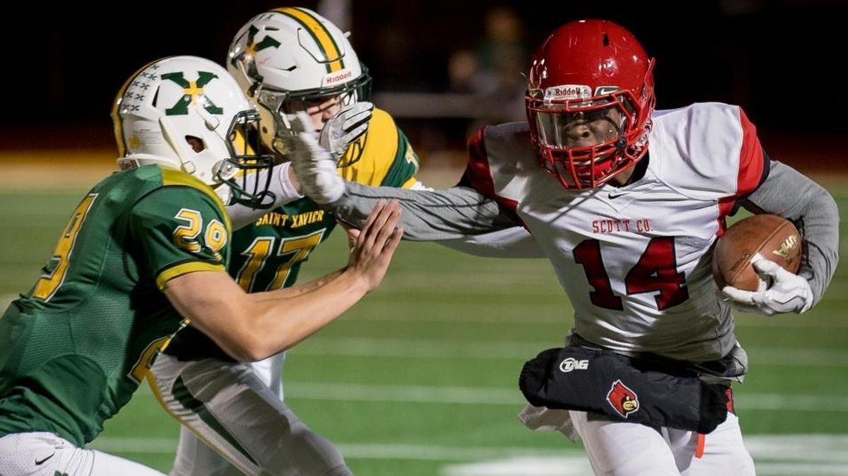 Scott County’s Glenn Covington (14) was tackled by St. Xavier’s Harrison Pate (29) and Sam Boarman (17) during the Class 6A semifinals in Louisville last November.