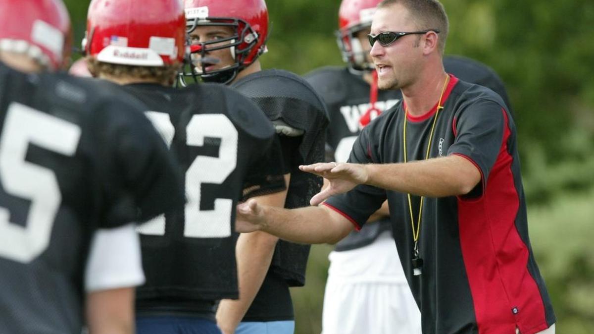 Wes Johnson, right, head coach of the West Jessamine High football team, talks to players during practice at the school Monday afternoon, August 8, 2005 in Nicholasville, KY.