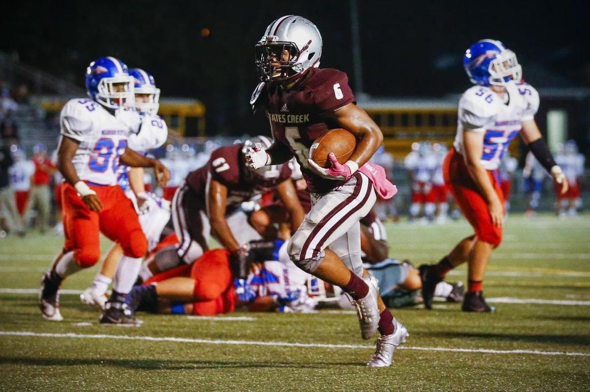 Tates Creek's Laron Warner (6) scores a touchdown past Madison Central defenders in the second quarter of their game at Tates Creek High School in Lexington, Ky., Thursday, Oct. 5, 2017.