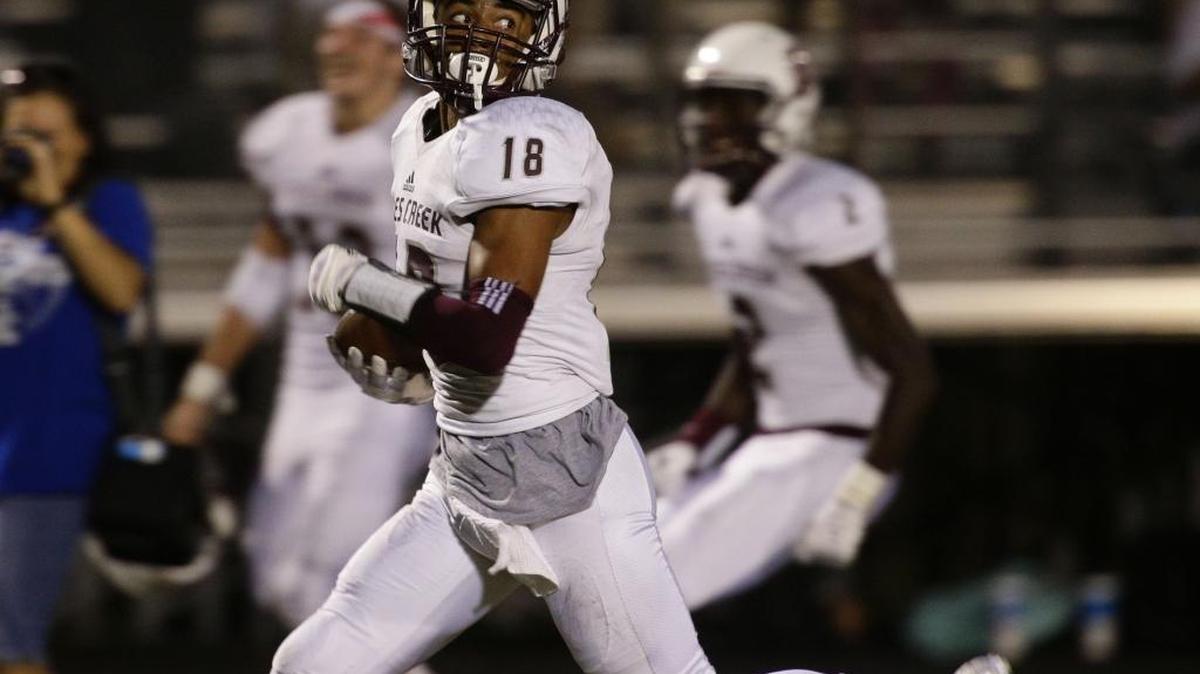 Tates Creek’s Turner Gentry took a look behind him as he outran the defense for a touchdown in the first quarter as Dunbar played Tates Creek on Friday September 2, 2016 in Lexington, Ky.