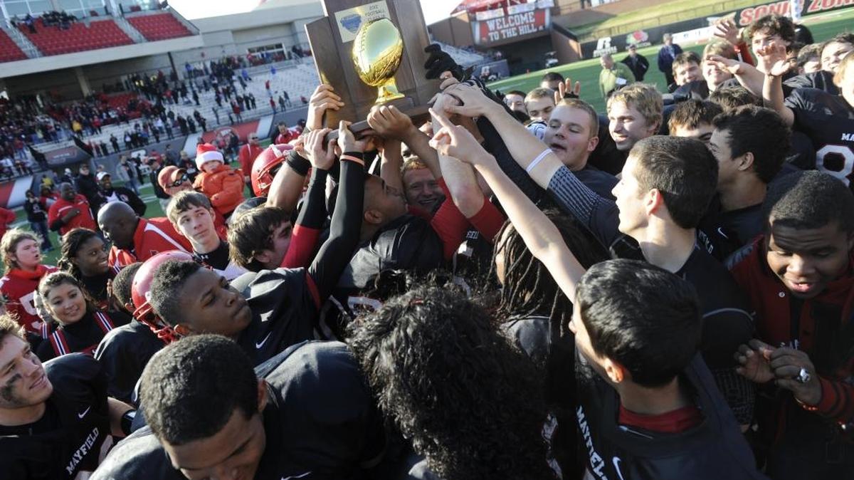 FILE PHOTO: Mayfield players hold up the championship trophy after their 55-8 win over Fairview in the KHSAA Class 1A Commonwealth Gridiron Bowl championship high school football game Friday, Nov. 30, 2012, in Bowling Green, Ky. It was the first of four consecutive football championships won by the Cardinals, who will seek their fifth straight title this season.