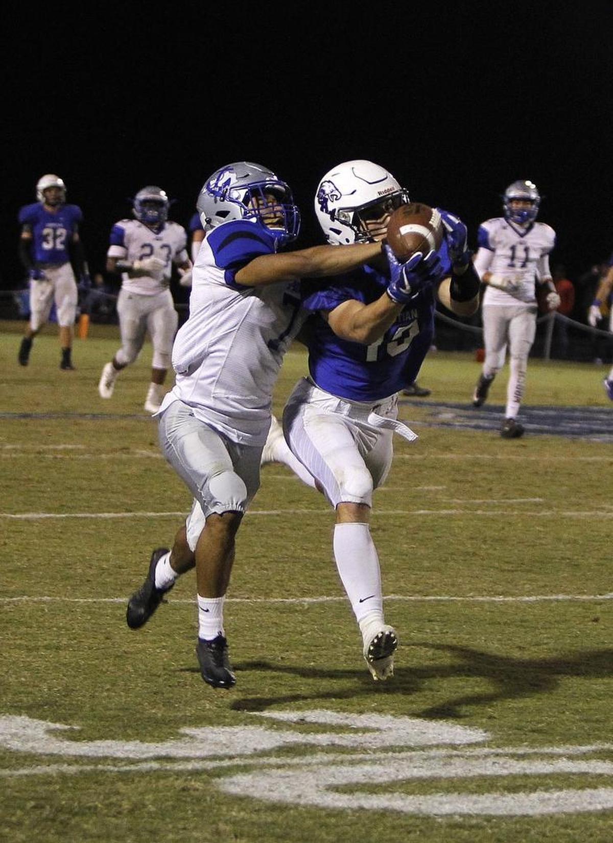 LCA's Drayden Burton makes the catch with pressure from Danville's Dmauriae VanCleave, left, at Lexington Christian Academy football stadium in Lexington, Ky., Friday, October 20, 2017.