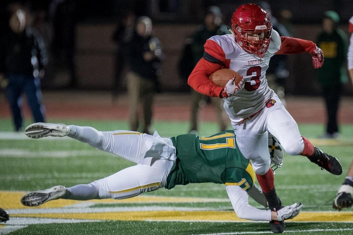 Scott County Cardinal's Brice Fryman (3) avoids the tackle of Saint Xavier Tiger's Sam Boarman (17) for a first down during the Kentucky State 6A semifinal football game in Louisville, Kentucky, November 24, 2017.