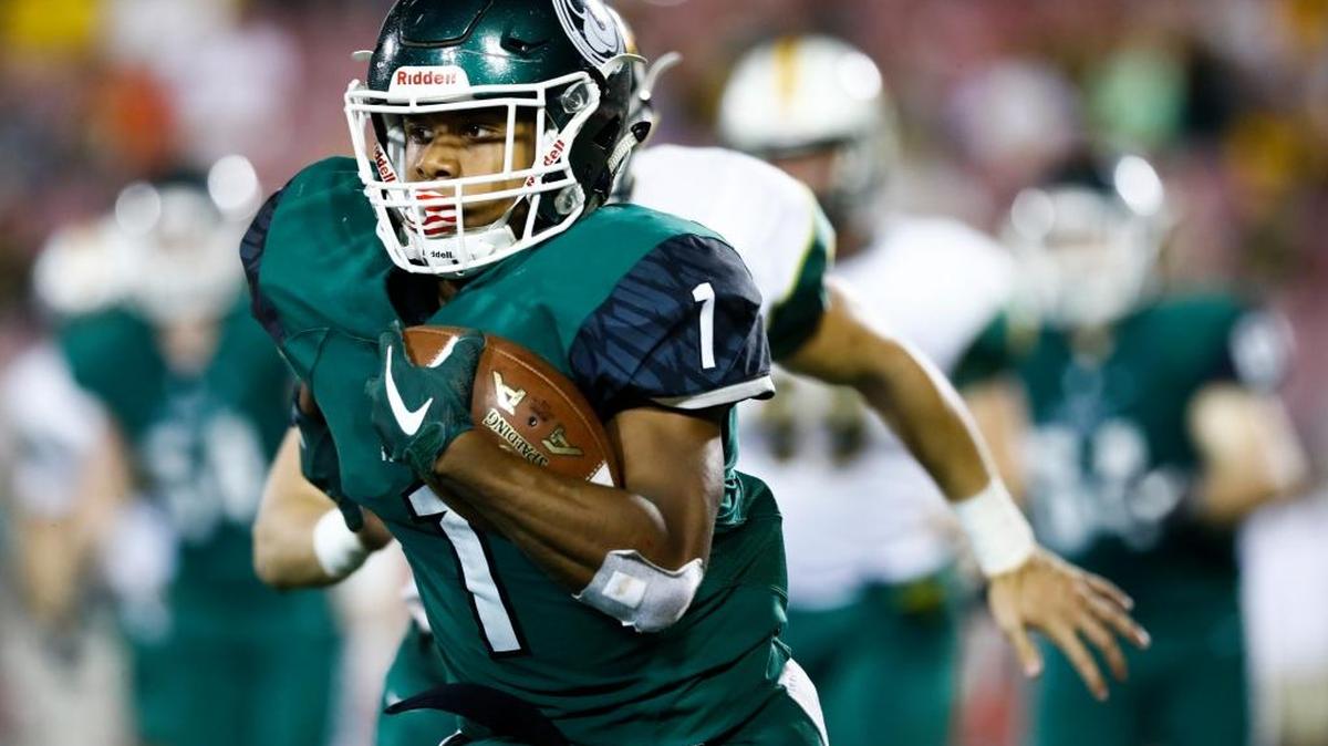 Trinity's Rondale Moore (1) runs the ball past St. Xavier's Peyton Mattingly (21) during their game at Papa John's Cardinal Stadium in Louisville, Ky., Friday, Sept. 29, 2017. Trinity beat St. Xavier 28-0.