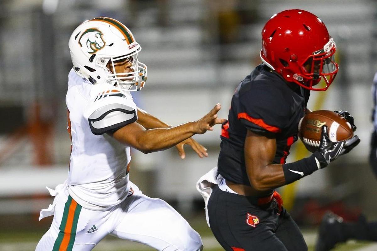 Scott County's Glenn Covington (14) runs the ball past Frederick Douglass' Theo Overton (7) during their game at Toyota Stadium in Georgetown, Ky., Friday, Oct. 6, 2017. Scott County beat Frederick Douglass 55-21.