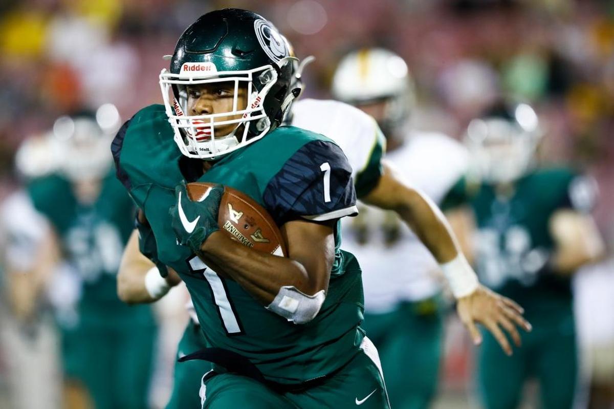 Trinity's Rondale Moore (1) runs the ball past St. Xavier's Peyton Mattingly (21) during their game at Papa John's Cardinal Stadium in Louisville, Ky., Friday, Sept. 29, 2017. Trinity beat St. Xavier 28-0.