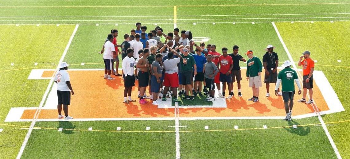 Head coach Brian Landis, middle, huddled with the team after a talk at mid-field during Frederick Douglass High School’s football practice at the new school, 2000 Winchester Rd. in Lexington, Ky., Friday, July 14, 2017. The school will open this fall.
