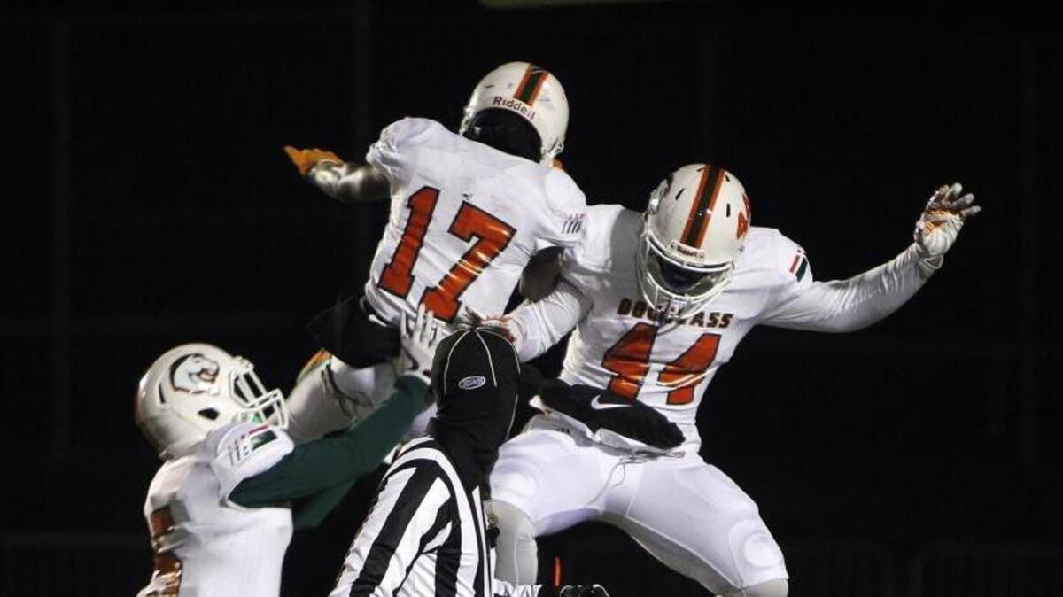 Frederick Douglass' Cameron Kennedy (47) celebrated with Nate Gay and Micah Lowe (17) after he ran for a touchdown in the Broncos’ 34-21 win at Tates Creek in the Class 6A playoffs on Friday.