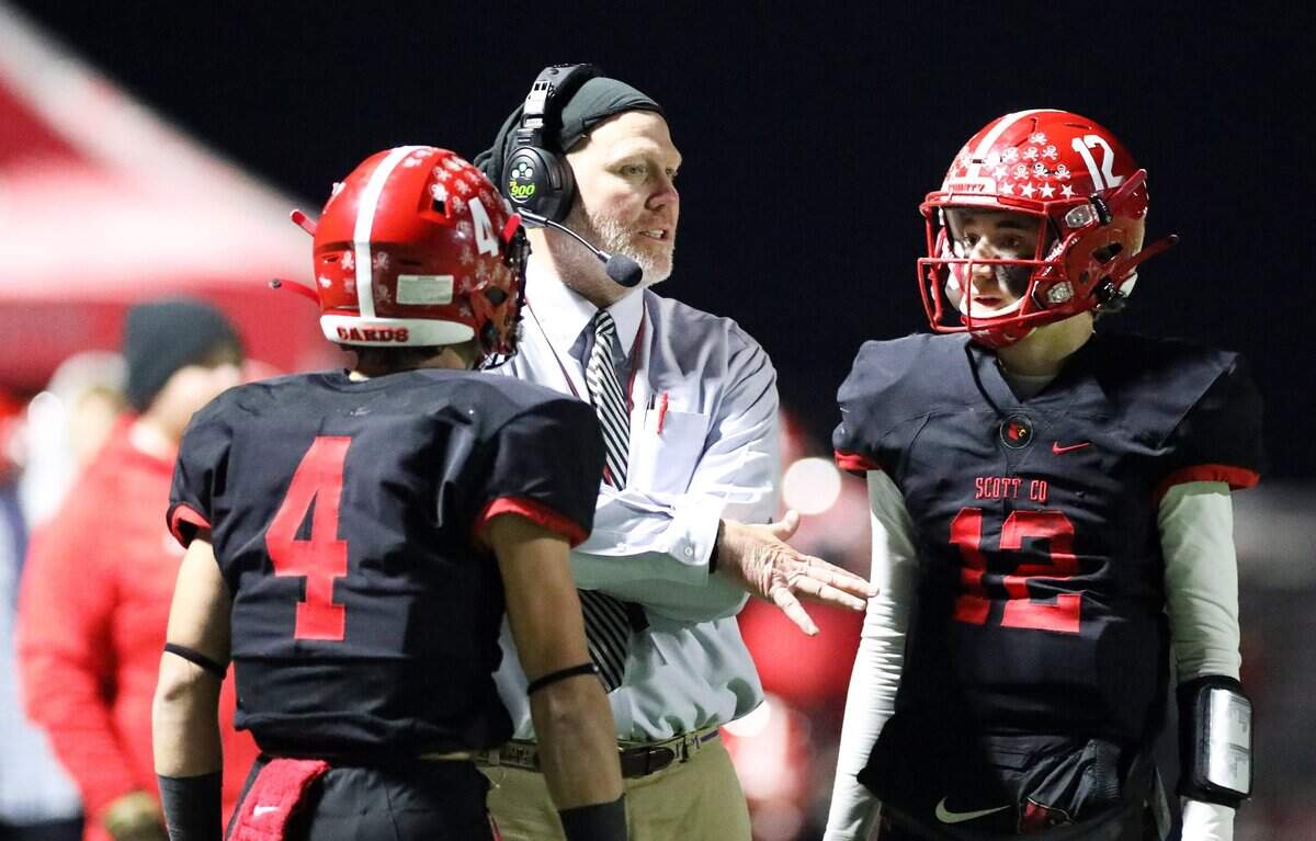 Scott County head coach Jim McKee talked with Paul Garner (4), left, and quarterback Andrew Hickey (12) during their game against Great Crossing last year. Hickey returns at QB this season for the Cardinals.