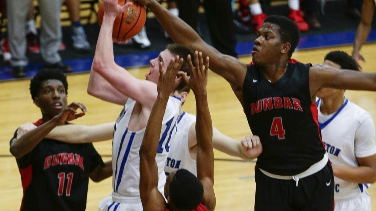 Paul Dunbar’s Dontell Brown, right, blocked a shot by Lexington Catholic’s Luke Johnson on Dec. 11, 2015.
