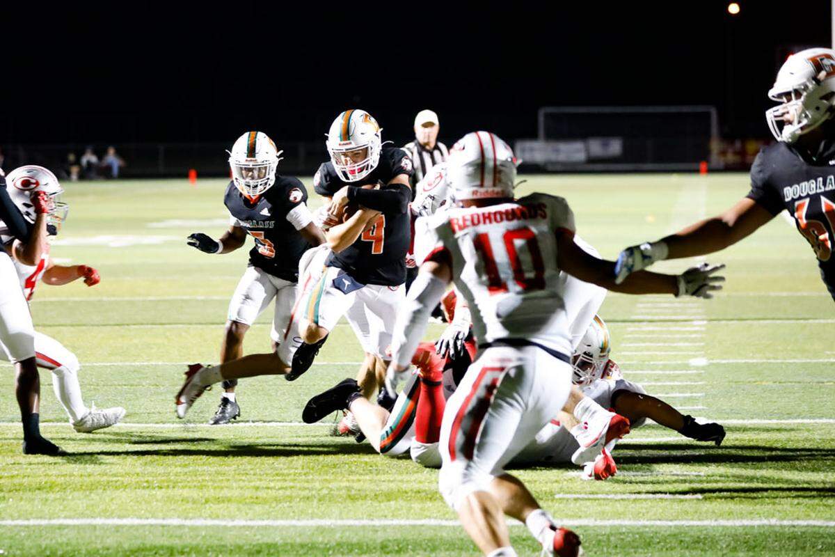 Frederick Douglass quarterback Jaxon Strautman secures the ball as he breaks through Corbin’s defense for a touchdown in the first half of the Broncos’ 35-14 win over the Redhounds at The Farm on Friday.