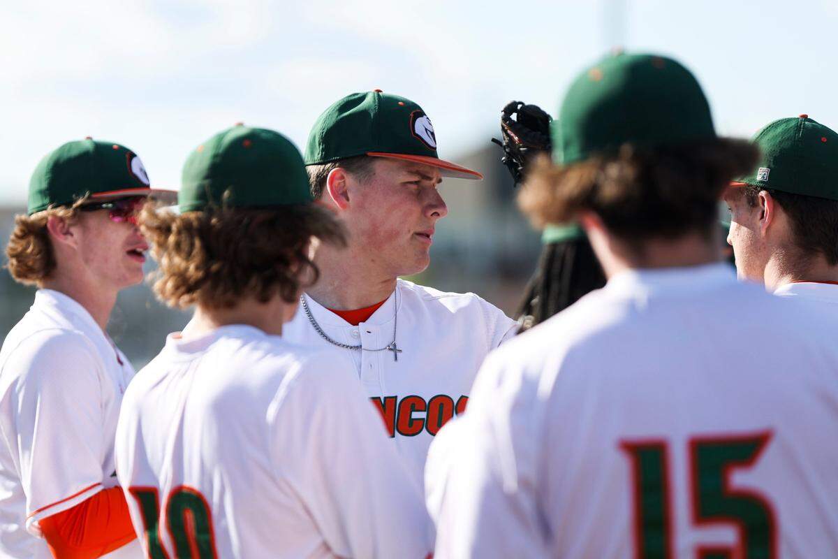 Frederick Douglass senior Thomas Howard, center, committed to play baseball at the University of Louisville as a high school freshman.