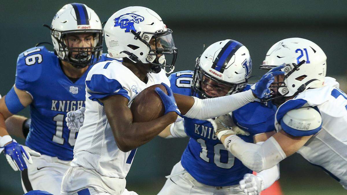 Lexington Catholic’s Hayden Dawahare, left, and Corbin Perry (10) pursued Lexington Christian’s Evan Brown (1) during their annual “Holy War” high school football rivalry game last season. The teams meet this year on Sept. 15.
