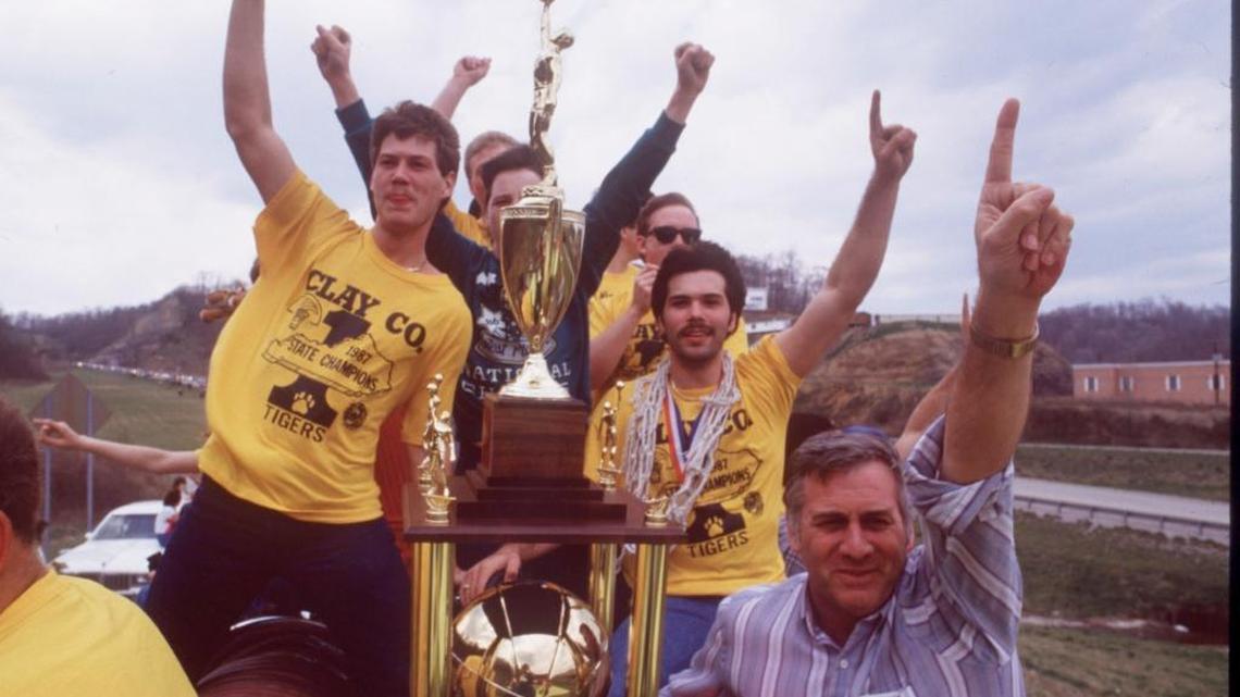 After Clay County won the first boys’ state basketball championship in 1987 for a team from the Eastern Kentucky mountains since Carr Creek in 1956, Coach Bobby Keith, front right, and and star player Richie Farmer, directly behind Keith wearing medallion, celebrated atop a fire truck as they returned to home.