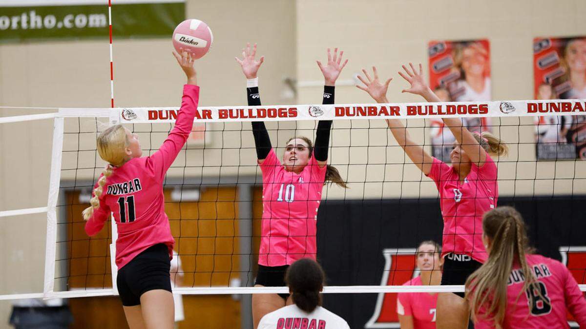 Paul Laurence Dunbar’s Mya McDowell (11) tries to get the ball over the defense of Lexington Catholic’s Payton Avilez (10) and Shay Pope (9) at Paul Laurence Dunbar High School on Tuesday.