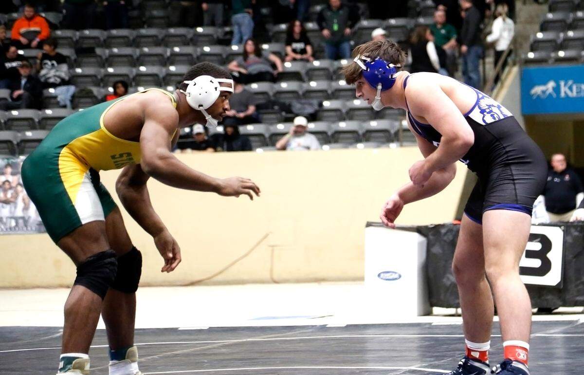 Bryan Station’s Jahvon Frazier, left, squares off against Paducah Tilghman’s Jack James in the 215 class finals at the boys/coed KHSAA State Wrestling Championships at the Kentucky Horse Park’s Alltech Arena on Friday.